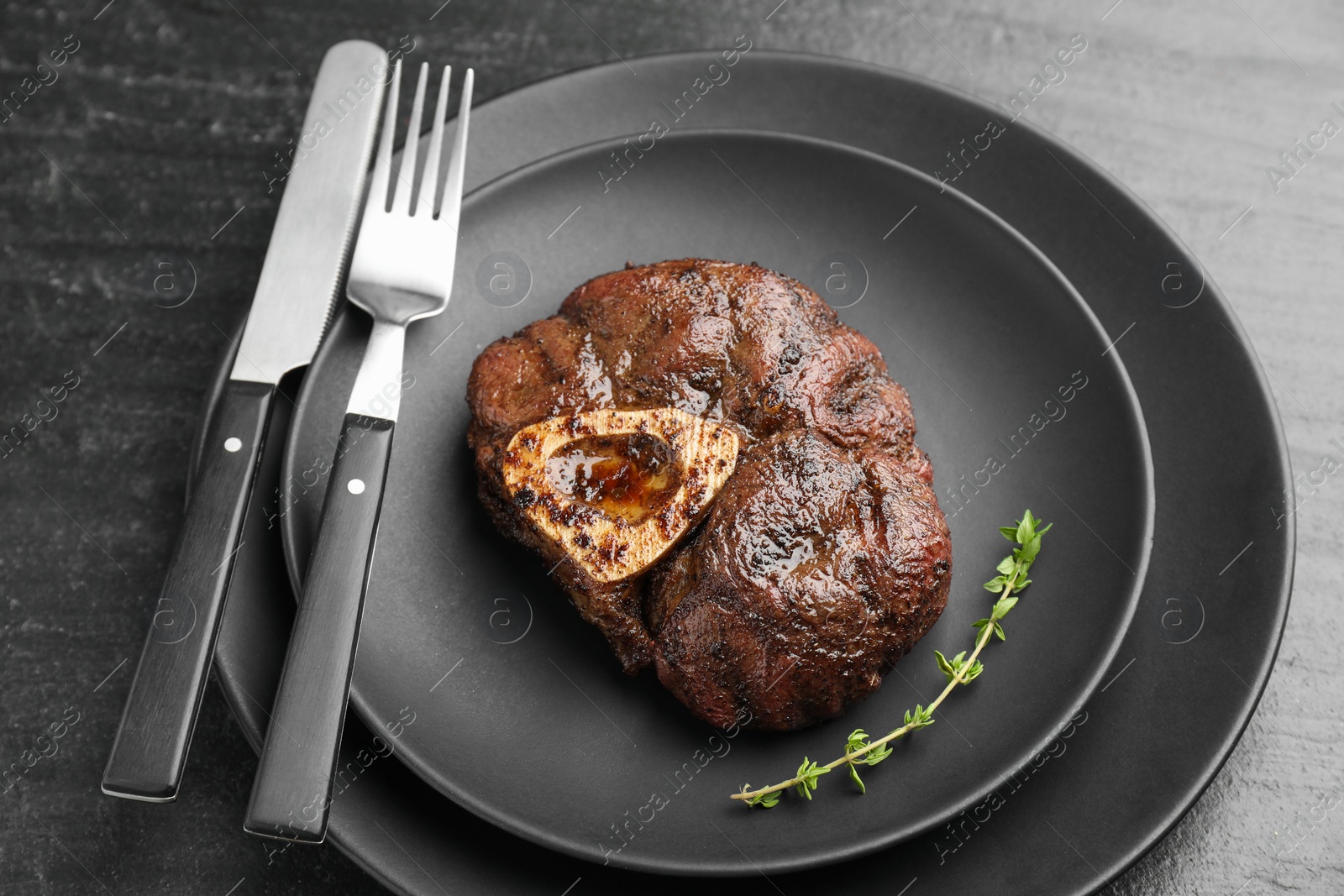 Photo of Tasty grilled beef meat served on black table, closeup