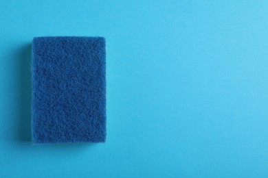 New sponge on light blue background, top view. Space for text