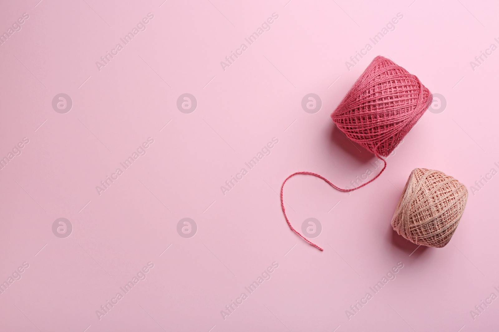 Photo of Clews of knitting threads on color background, flat lay with space for text. Sewing stuff