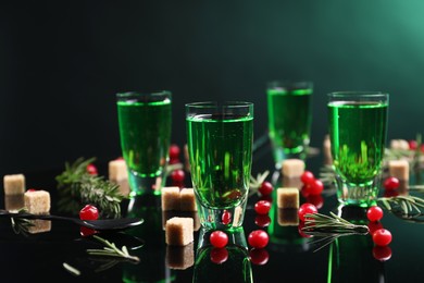 Photo of Absinthe in shot glasses, cranberries, rosemary and brown sugar on mirror table. Alcoholic drink