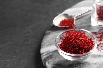 Photo of Dried saffron on black table, closeup. Space for text