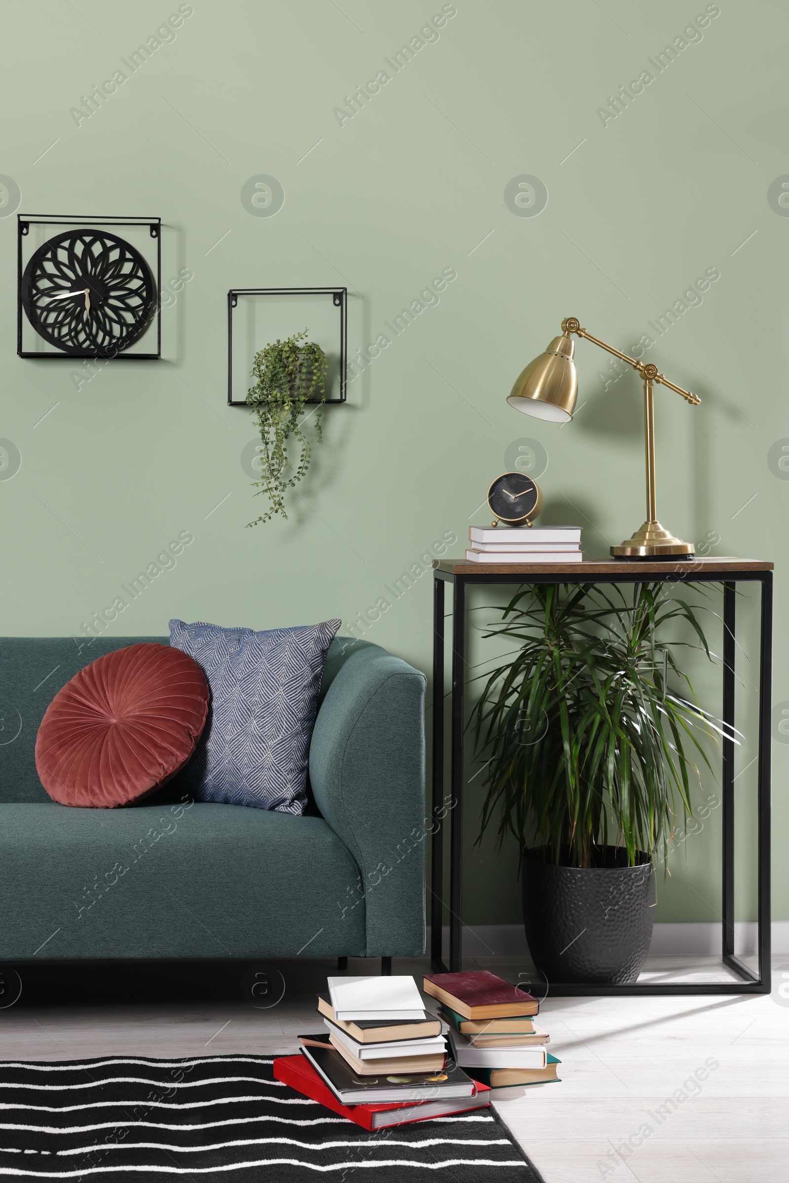 Photo of Stylish interior with comfortable sofa and cushions near console table