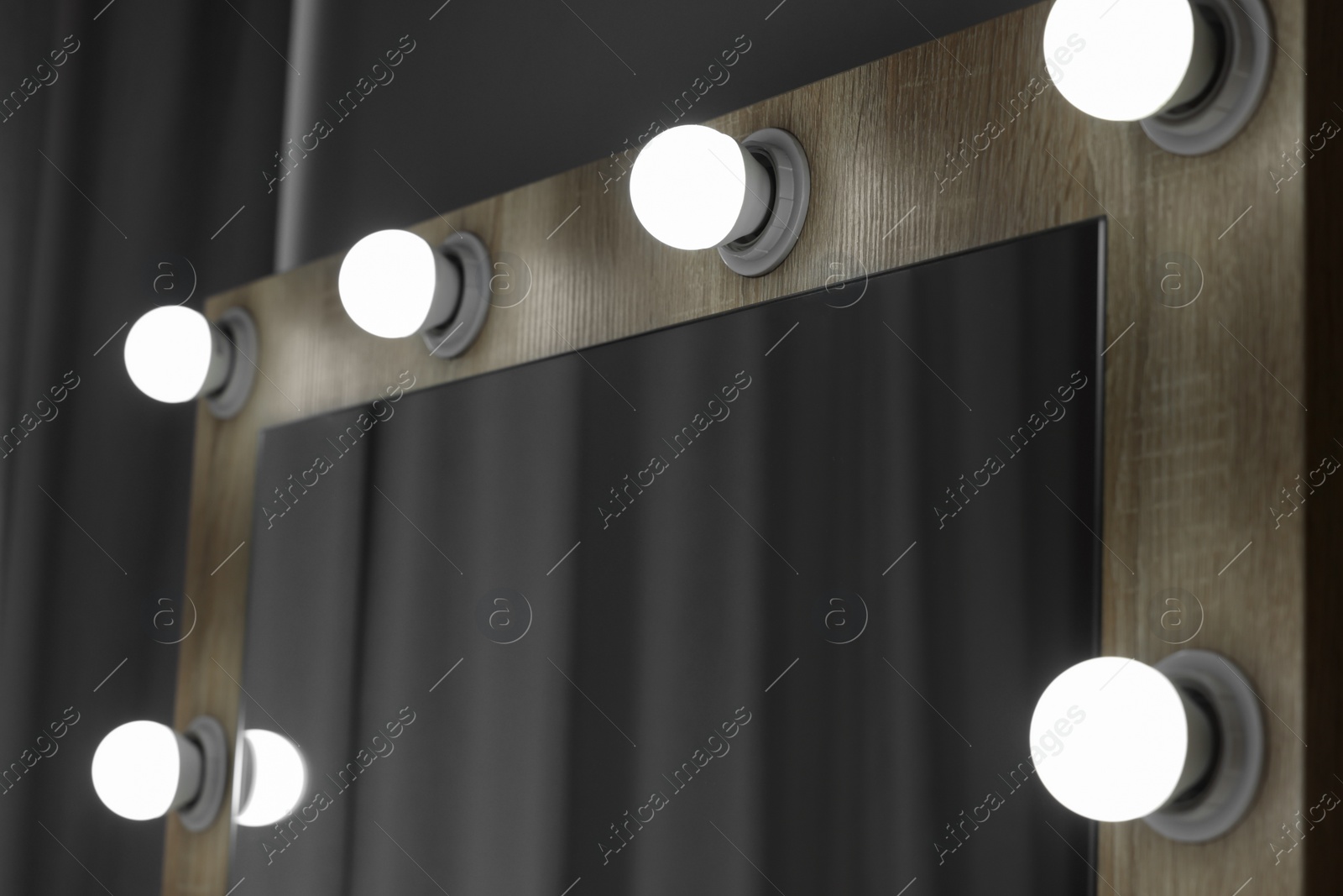 Photo of Beautiful mirror with light bulbs in makeup room, closeup