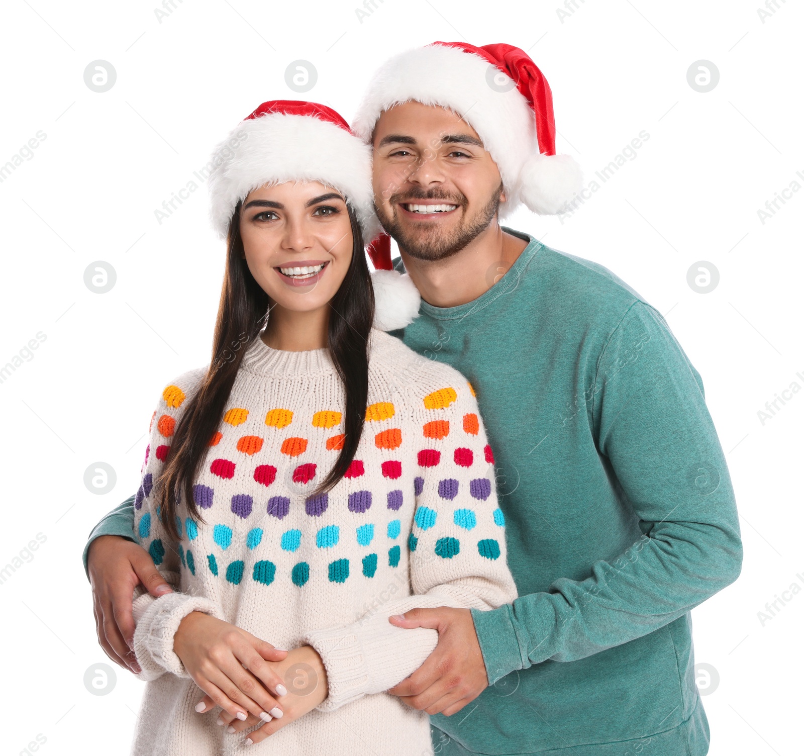 Photo of Lovely young couple in Santa hats on white background. Christmas celebration