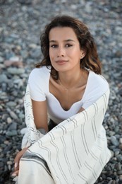 Photo of Portrait of happy young woman on pebble beach