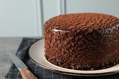 Photo of Delicious chocolate truffle cake and knife on table, closeup