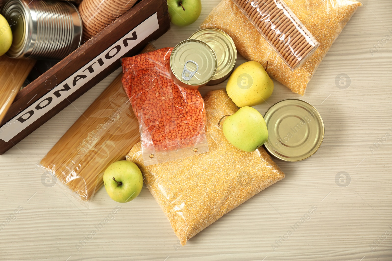 Photo of Donation box and different products on wooden table, top view