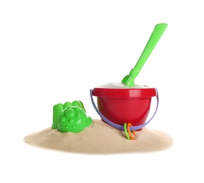 Photo of Set of plastic beach toys and pile of sand on white background