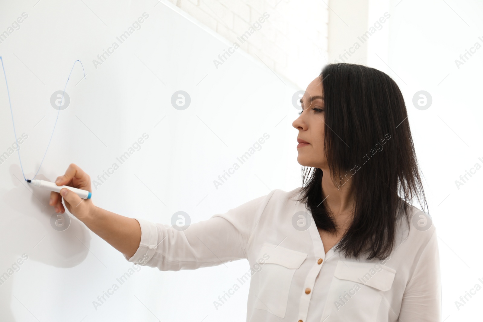 Photo of Professional business trainer near whiteboard in office