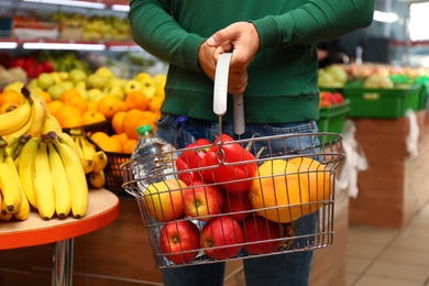 Photo of Man with shopping basket in supermarket, closeup