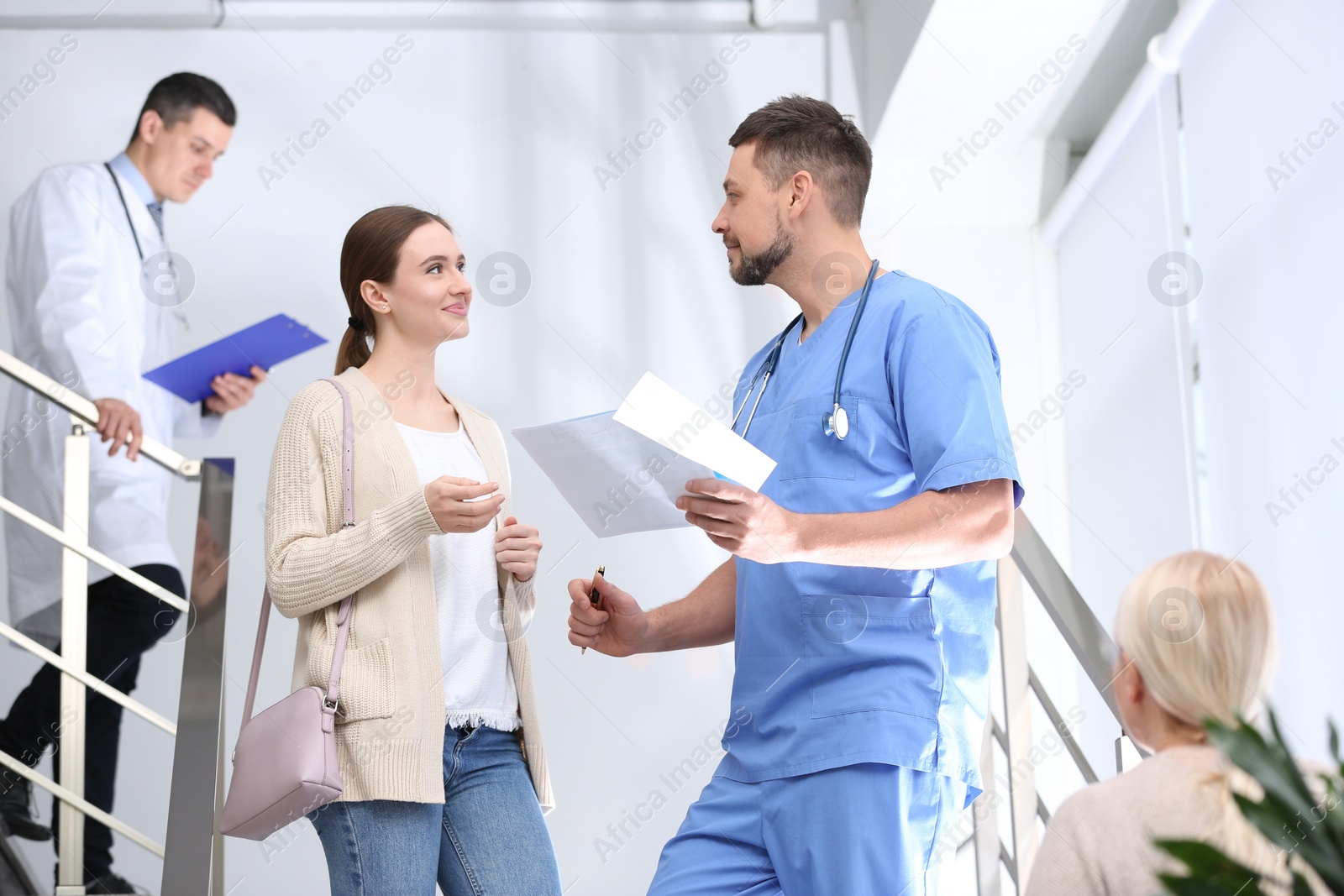 Photo of Doctor and patient discussing diagnosis on stairs in hospital