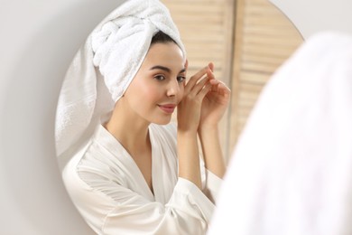 Photo of Beautiful happy woman in stylish bathrobe near mirror