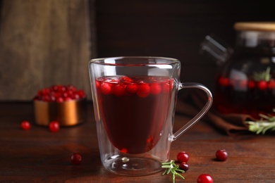 Photo of Tasty hot cranberry tea on wooden table