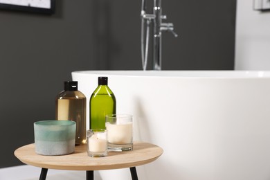 Photo of Candles and care products on table in bathroom. Space for text