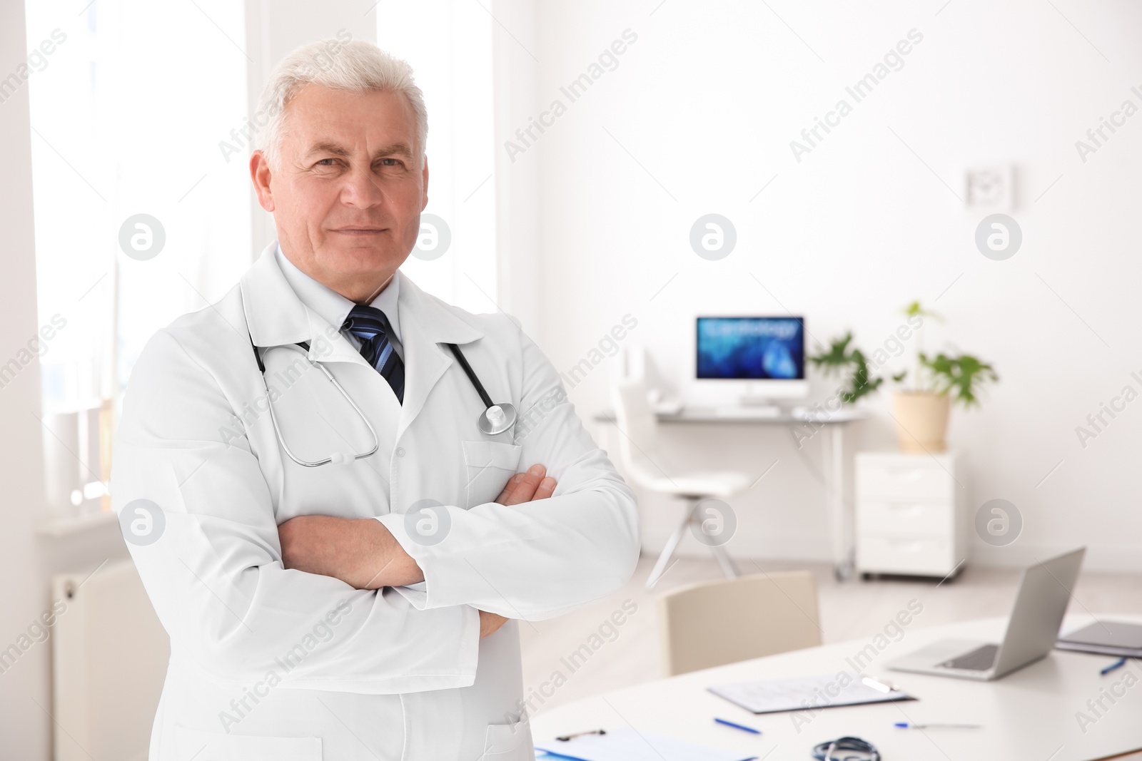 Photo of Portrait of male doctor in coat at workplace in clinic. Cardiology center