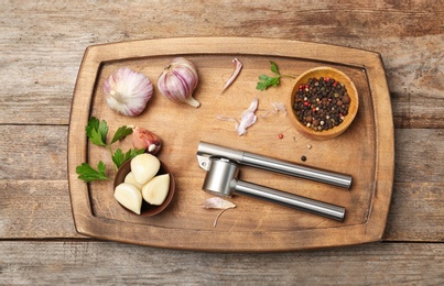 Photo of Flat lay composition with garlic press on wooden table