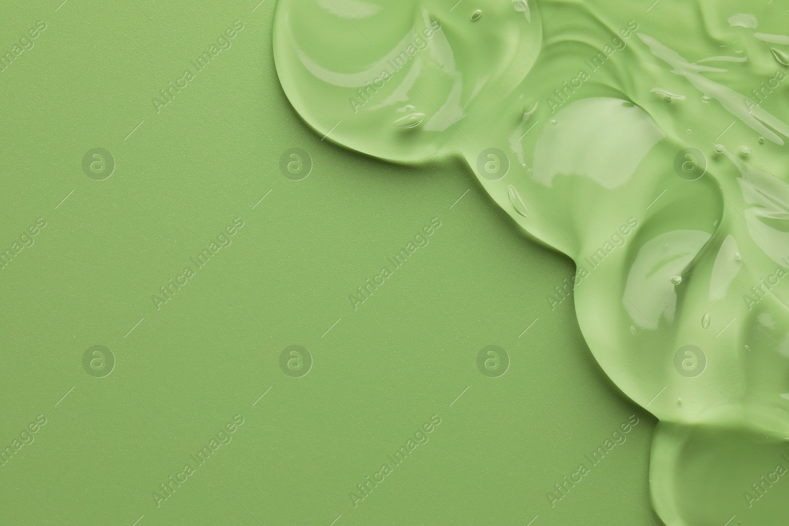 Photo of Clear cosmetic gel on light green background, top view. Space for text