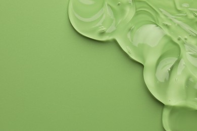 Photo of Clear cosmetic gel on light green background, top view. Space for text