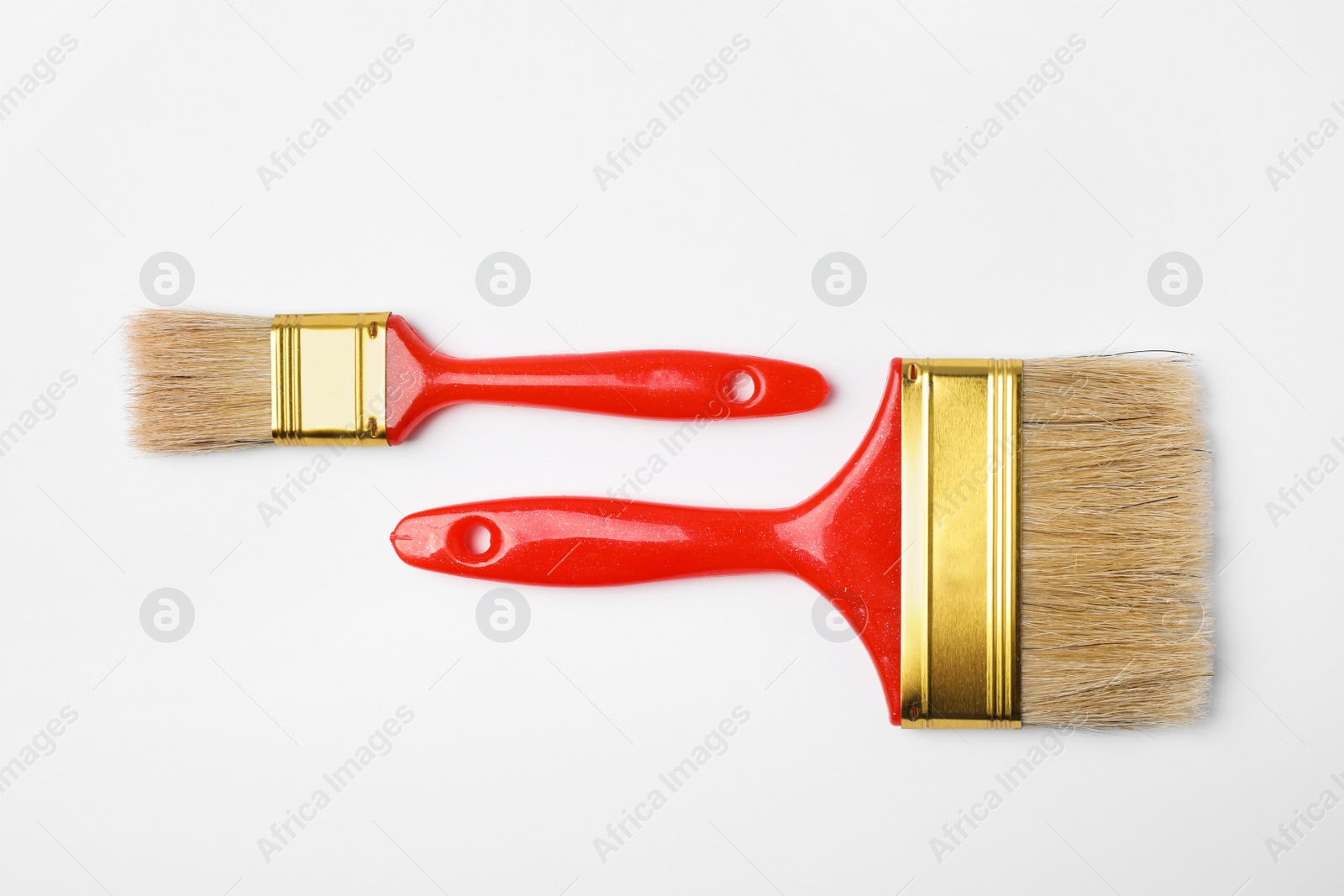 Photo of Paint brushes on color background, top view