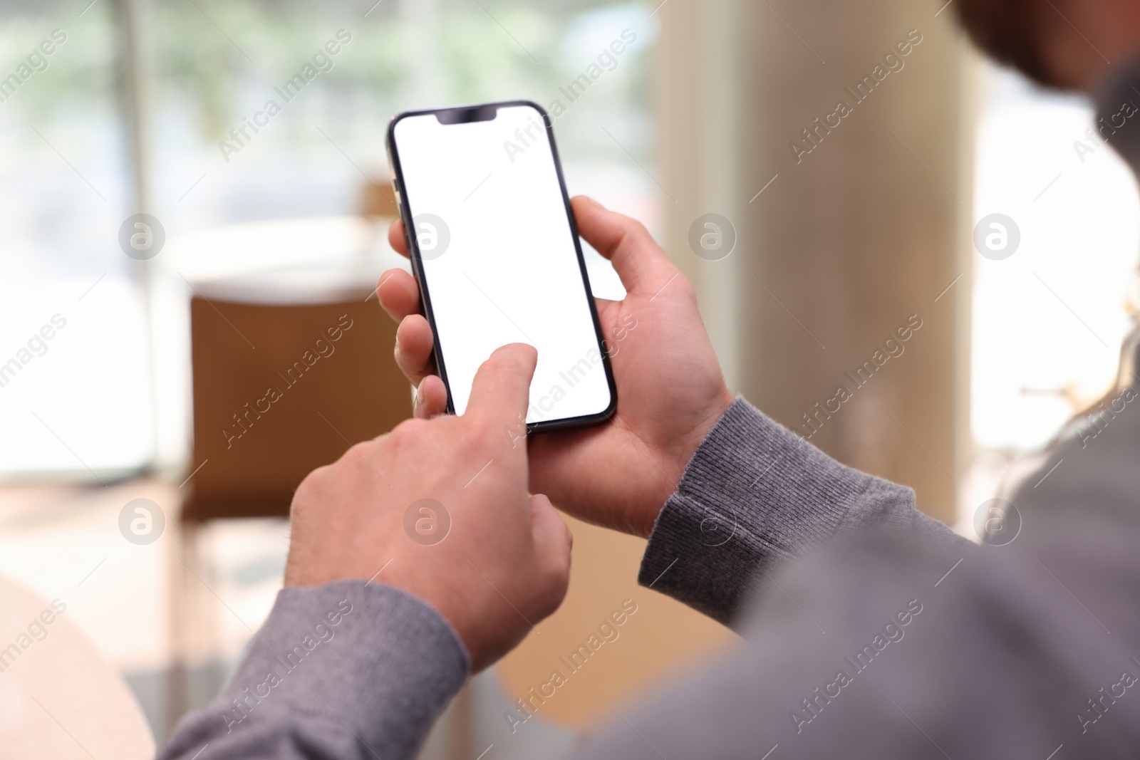 Photo of Man using his smartphone in cafe, closeup