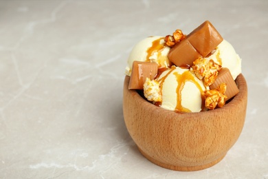 Delicious ice cream served with caramel popcorn and sauce on table. Space for text
