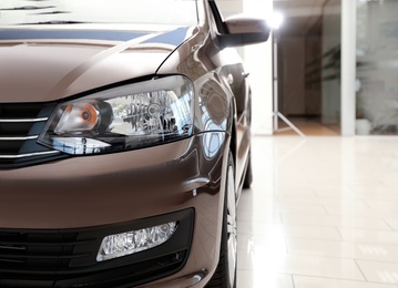 Photo of New luxury car in modern auto dealership, closeup