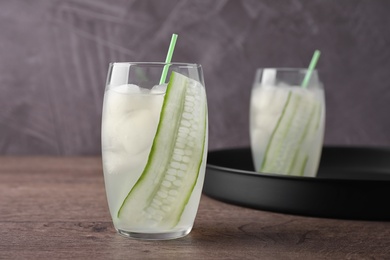Photo of Glasses of tasty cucumber martini cocktail on wooden table
