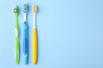 Photo of Many different toothbrushes on light blue background, flat lay. Space for text