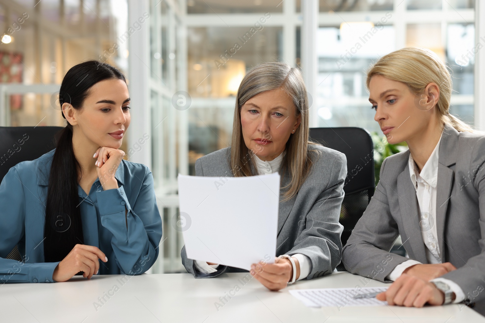 Photo of Lawyers working together with documents at table in office