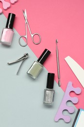 Nail polishes and set of pedicure tools on color background, flat lay