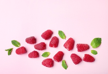 Flat lay composition with delicious ripe raspberries on pink background