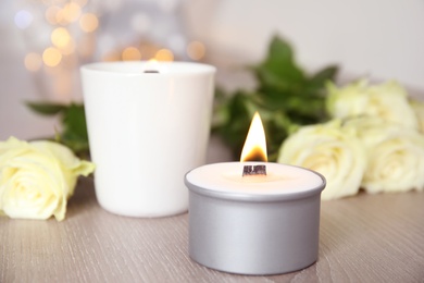 Burning candle with wooden wick on table