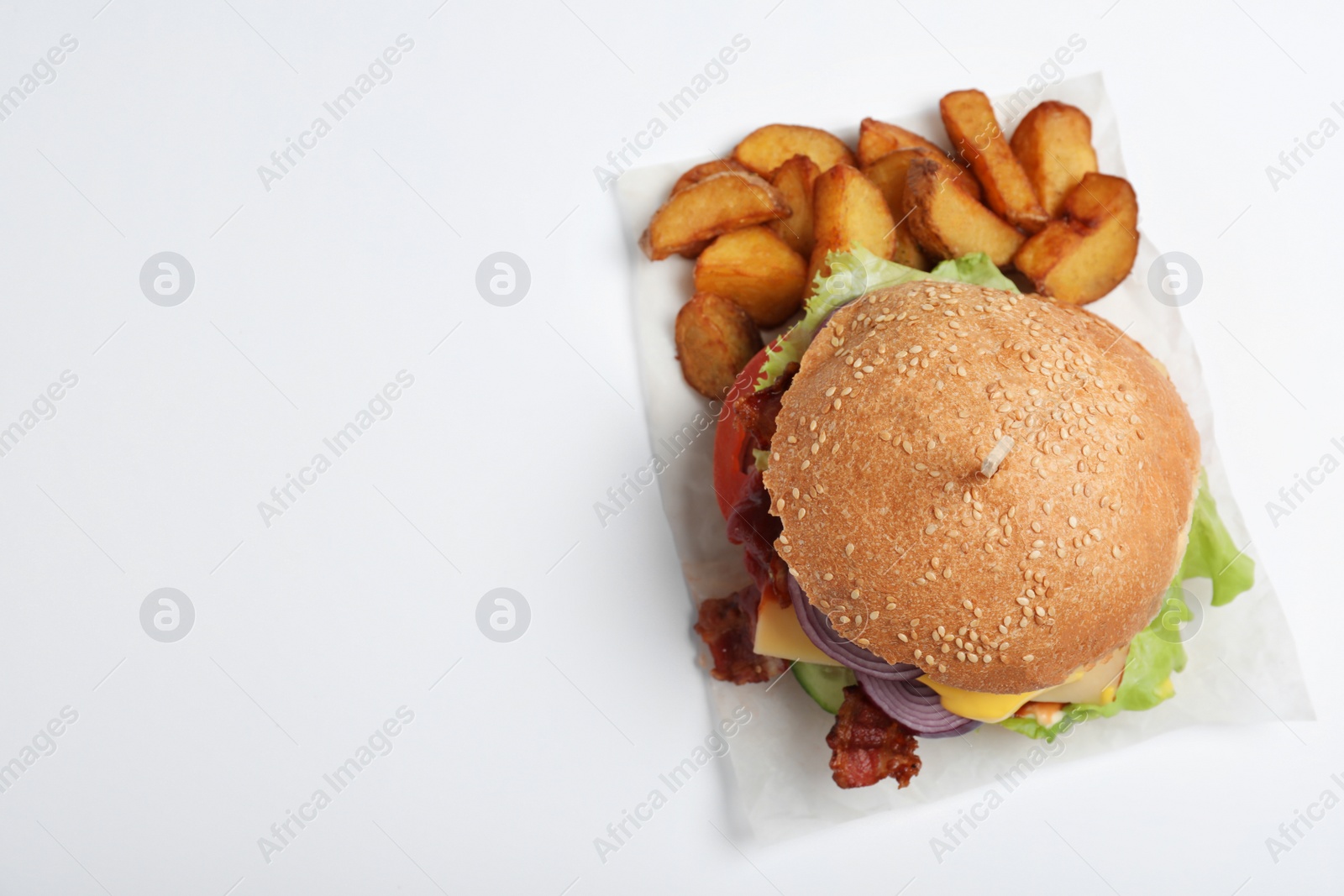 Photo of Fresh burger with fried potatoes on white background, top view