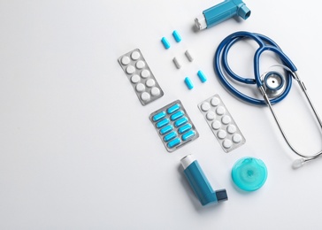 Photo of Flat lay composition with stethoscope, asthma medications and space for text on white background