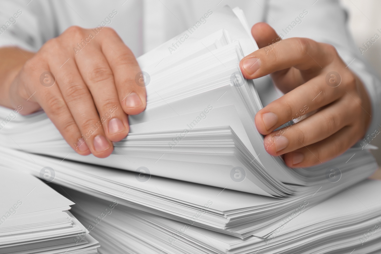 Photo of Man stacking documents in office, closeup view