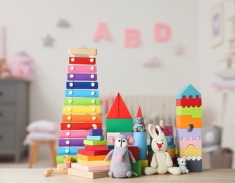 Set of different cute toys on wooden table in children's room