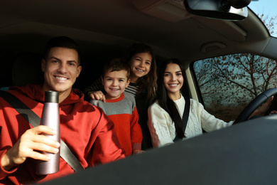 Photo of Happy family with little children inside modern car