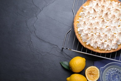 Photo of Flat lay composition with delicious lemon meringue pie on black table. Space for text