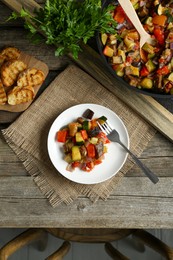 Delicious ratatouille served on wooden table, flat lay