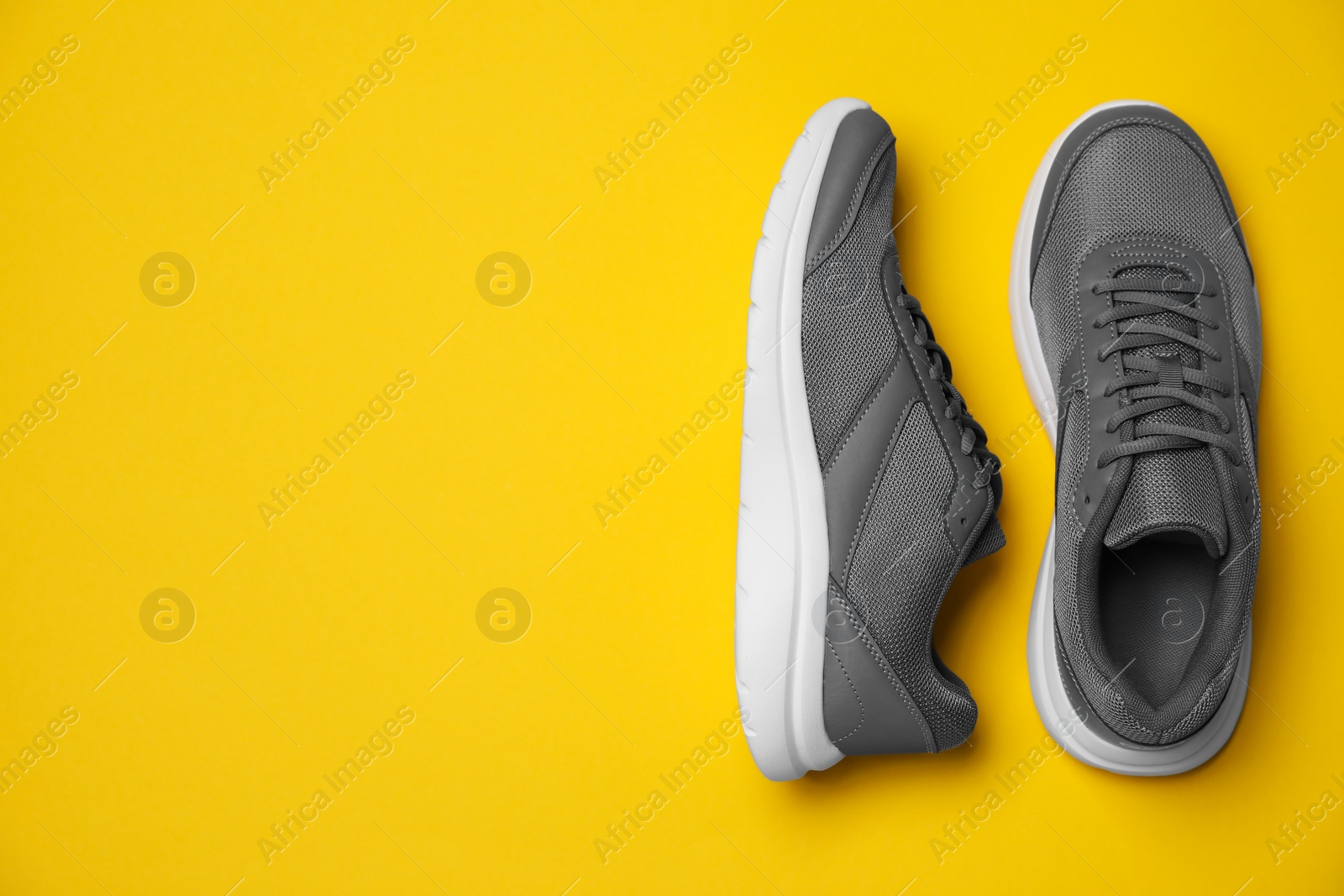 Photo of Pair of stylish sport shoes on orange background, flat lay. Space for text