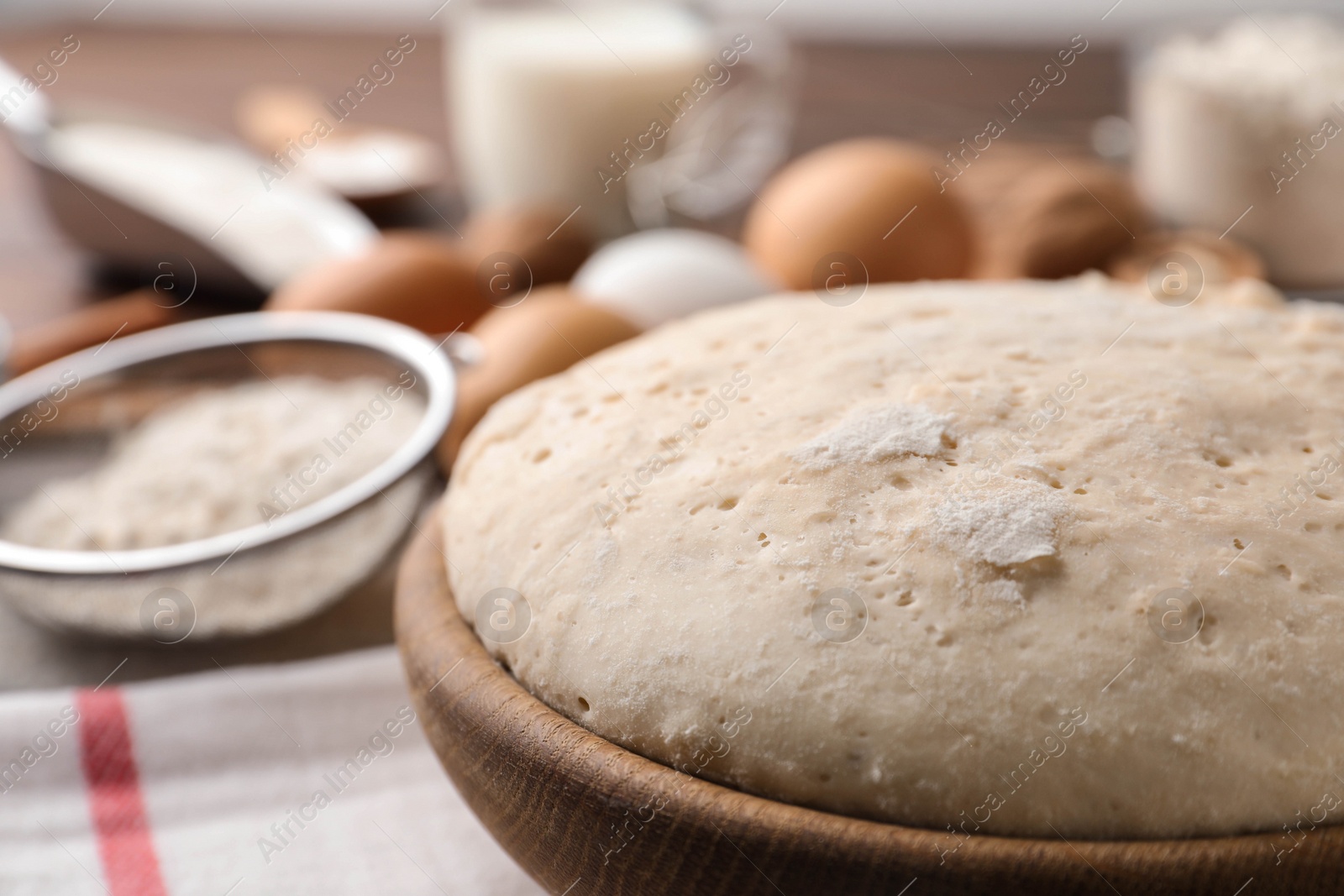 Photo of Bowl with dough for pastries on table, closeup