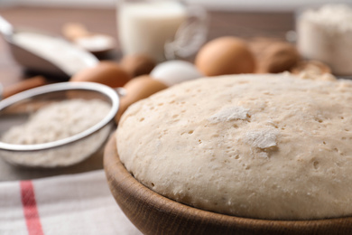 Bowl with dough for pastries on table, closeup