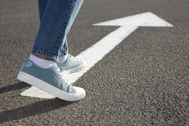 Photo of Woman going along road with arrow marking, closeup