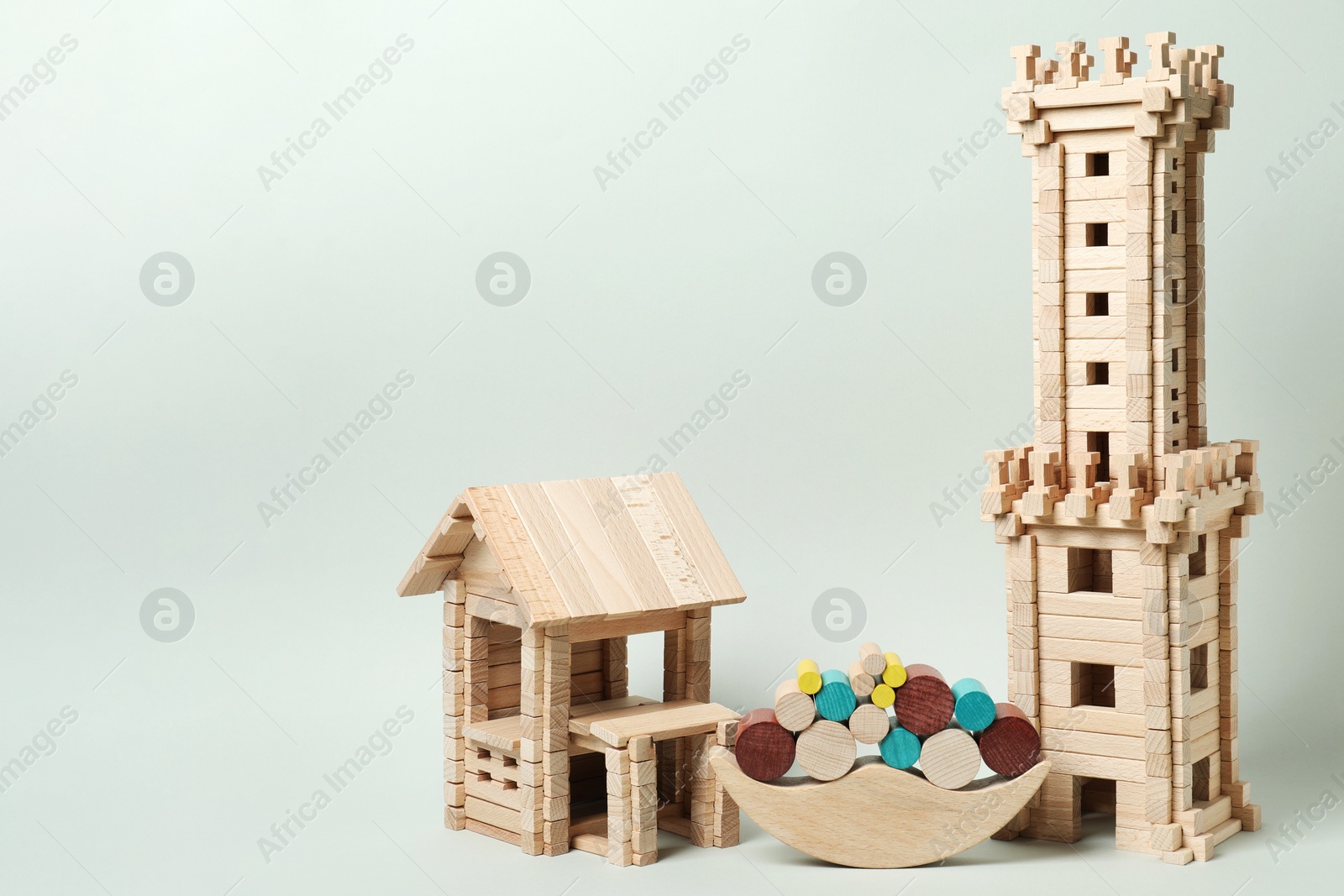 Photo of Set of wooden toys on pale light green background, space for text. Children's development