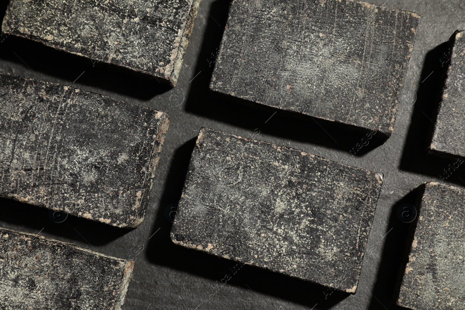 Photo of Natural tar soap on black background, flat lay