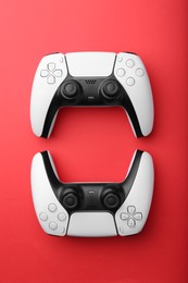 Photo of Wireless game controllers on red background, flat lay