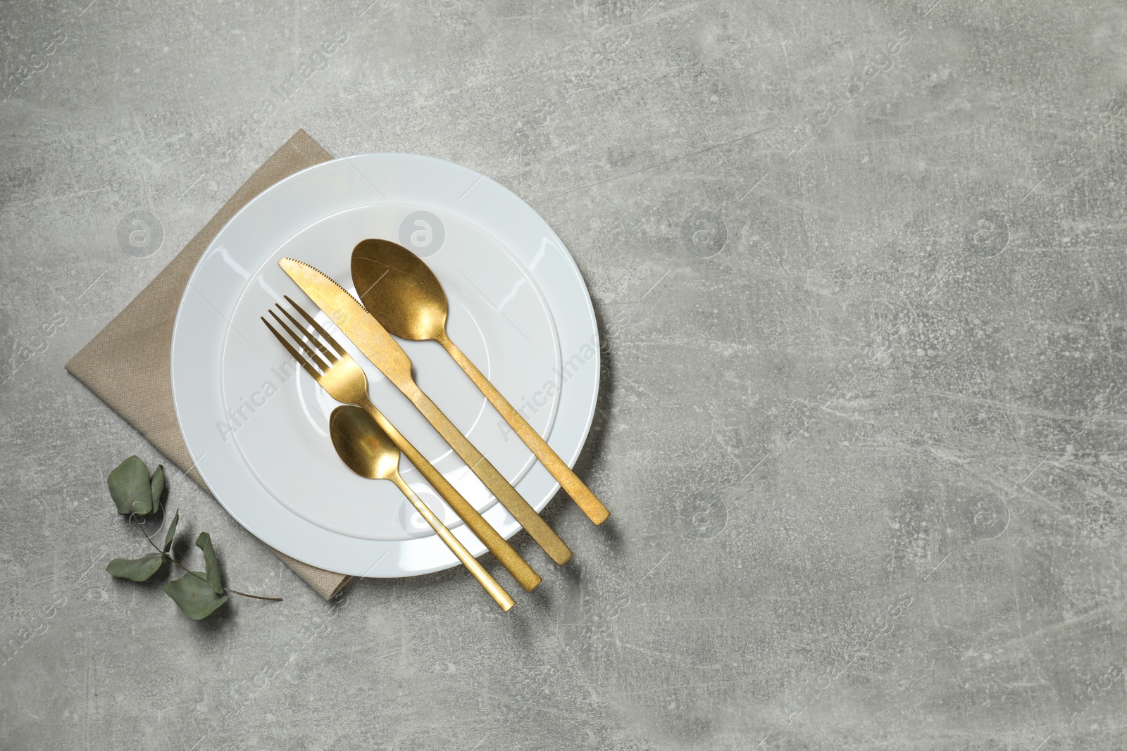 Photo of Stylish setting with elegant cutlery on grey table, top view. Space for text