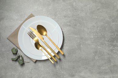 Photo of Stylish setting with elegant cutlery on grey table, top view. Space for text