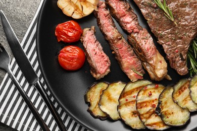 Photo of Delicious grilled beef steak with vegetables served on table, flat lay