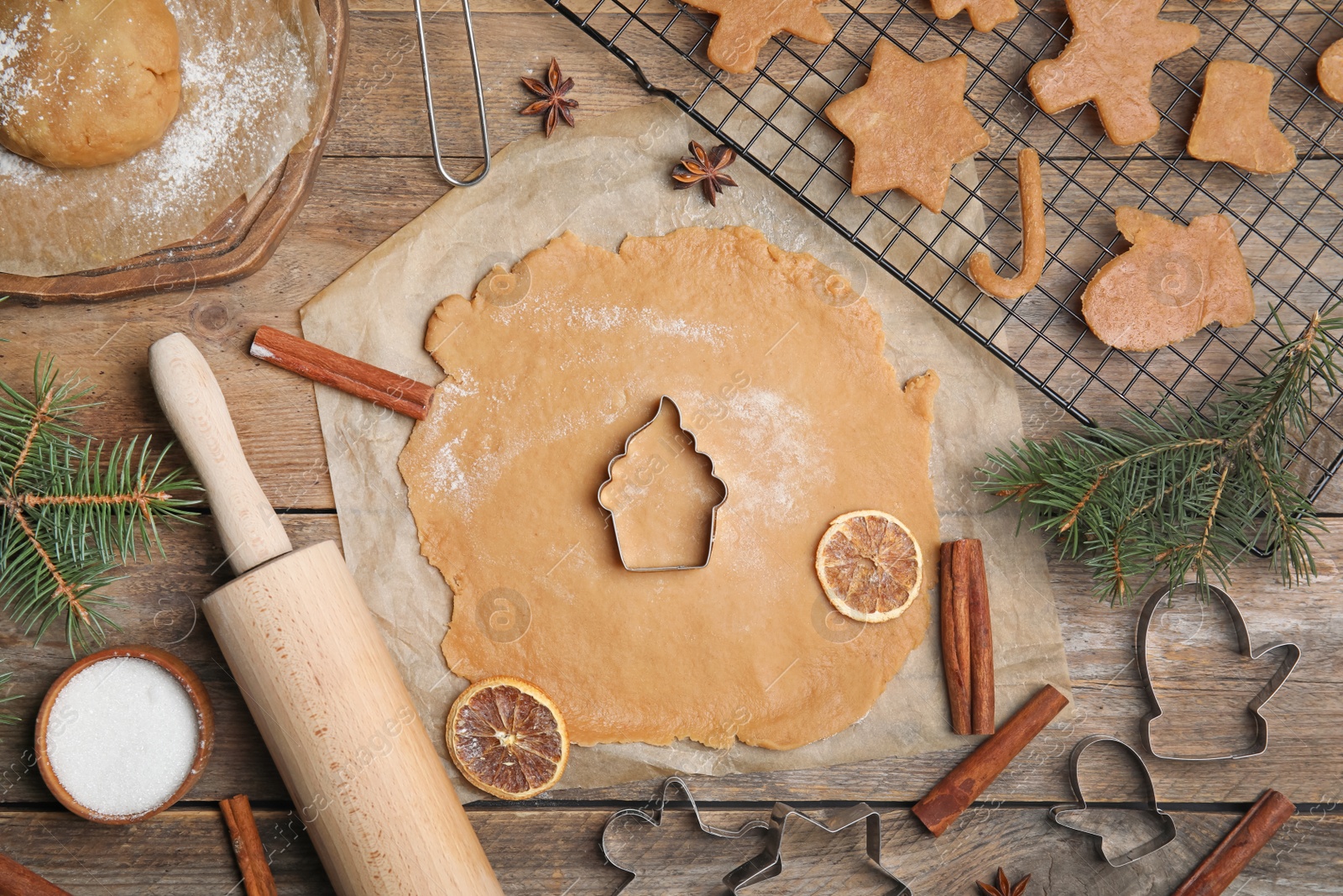 Photo of Making homemade Christmas cookies. Flat lay composition with dough and cutters on wooden background